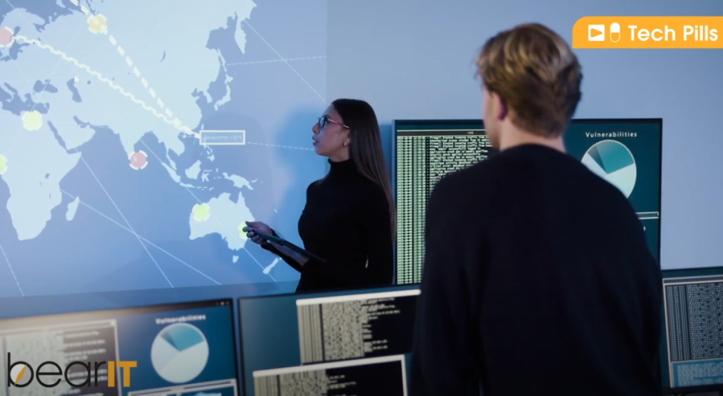 Una professionista della cyber security illustra su una immagine prioettata le possibili minacce informatiche in un Security Operation Center